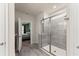 Bathroom featuring a glass-enclosed shower with gray tiles and an entry to the main bedroom at 5920 Hart Way, Cumming, GA 30028