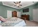 Spacious bedroom featuring a ceiling fan, tray ceiling, and dark wood furniture set against sage-green walls at 5920 Hart Way, Cumming, GA 30028