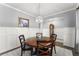 Dining room features a round wooden table and decoratively paneled walls lit by a globe chandelier at 5920 Hart Way, Cumming, GA 30028
