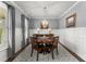 Traditional dining room with wainscoting, and a round wooden table lit by a stylish chandelier at 5920 Hart Way, Cumming, GA 30028
