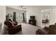 Comfortable living room with leather seating, ceiling fan, and a view into an adjacent bedroom at 5920 Hart Way, Cumming, GA 30028