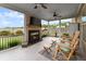 Cozy screened porch with a fireplace, ceiling fans, and comfortable seating for outdoor living at 5920 Hart Way, Cumming, GA 30028