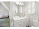 Bathroom featuring a single sink vanity with white cabinets, large mirror, window with shutters, and toilet at 1285 Wesley Nw Pl, Atlanta, GA 30327