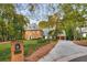 Stately brick home with mature trees and manicured landscaping, featuring a long driveway and mailbox at 1285 at 1285 Wesley Nw Pl, Atlanta, GA 30327