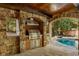 Inviting outdoor kitchen with stone features, built-in grill, stainless appliances, and a view of the pool at 1285 Wesley Nw Pl, Atlanta, GA 30327