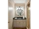Stylish powder room with a round mirror, granite countertop, and modern lighting at 1285 Wesley Nw Pl, Atlanta, GA 30327