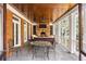 Outdoor screened porch with stone fireplace, wood ceiling, seating and dining area at 1285 Wesley Nw Pl, Atlanta, GA 30327