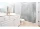 Well-lit bathroom with white cabinets, a large mirror, and a shower-tub combination with a striped curtain at 1850 Cotillion Dr # 4306, Dunwoody, GA 30338