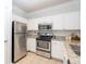 Well-lit kitchen featuring granite countertops and stainless steel appliances and tile flooring at 1850 Cotillion Dr # 4306, Dunwoody, GA 30338