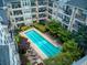 An aerial shot of the community swimming pool surrounded by trees and condominium buildings with balconies at 1850 Cotillion Dr # 4306, Dunwoody, GA 30338