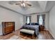 Bedroom featuring a ceiling fan, grey curtains, and wood flooring at 1900 Shady Creek Ln, Lawrenceville, GA 30043