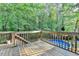 View from a wood deck with a wood railing overlooking the yard with a pool at 1900 Shady Creek Ln, Lawrenceville, GA 30043