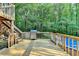 View from a wood deck and wood railing with a stainless steel grill and a pool at 1900 Shady Creek Ln, Lawrenceville, GA 30043