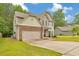 Charming two-story home features a stone-accented facade, well-manicured lawn, and attached two car garage at 2534 Grayton Loop, Villa Rica, GA 30180