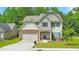 Charming two-story home with stone accents, a well-manicured lawn, and a welcoming entrance, perfect for Gathering living at 2534 Grayton Loop, Villa Rica, GA 30180