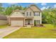 Charming two-story home features a stone-accented facade, well-manicured lawn, and attached two car garage at 2534 Grayton Loop, Villa Rica, GA 30180