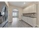 Kitchen features stainless appliances, granite counters, white cabinets, tile backsplash, and grey vinyl flooring at 2534 Grayton Loop, Villa Rica, GA 30180