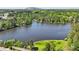 Stunning aerial view of a lake surrounded by trees, featuring a clear view of the neighborhood beyond at 4730 Geneva Sw Dr, Lilburn, GA 30047