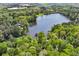 Stunning aerial view showcasing a serene lake surrounded by lush greenery and beautiful homes at 4730 Geneva Sw Dr, Lilburn, GA 30047
