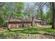 Expansive backyard featuring a brick patio, well-kept lawn, and lush greenery, perfect for outdoor enjoyment at 4730 Geneva Sw Dr, Lilburn, GA 30047