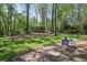 Spacious backyard patio with seating surrounded by lush trees, creating a serene outdoor retreat at 4730 Geneva Sw Dr, Lilburn, GA 30047