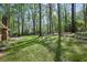 The spacious, green backyard features mature trees and a stone wall adding character and tranquility at 4730 Geneva Sw Dr, Lilburn, GA 30047