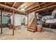 Unfinished basement with exposed beams, open stairs, and natural light, offering potential for customization at 4730 Geneva Sw Dr, Lilburn, GA 30047