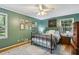 Charming bedroom boasts hardwood floors, a cozy bed, and multiple framed artworks on the green walls at 4730 Geneva Sw Dr, Lilburn, GA 30047