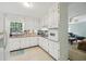 Bright kitchen with ample white cabinetry, tiled countertops, and a view into the cozy living area at 4730 Geneva Sw Dr, Lilburn, GA 30047