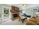Cozy living room boasts a brick fireplace, ceiling fan, and door to the outdoor space at 4730 Geneva Sw Dr, Lilburn, GA 30047