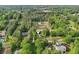 An aerial view of a modern farmhouse-style home surrounded by mature trees and other homes in a neighborhood at 4840 Moon Rd, Powder Springs, GA 30127