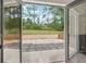 View of the landscaped backyard with mature trees through the open French doors at 4840 Moon Rd, Powder Springs, GA 30127