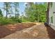 Large backyard features a gravel patio, lush green grass, and mature trees at 4840 Moon Rd, Powder Springs, GA 30127