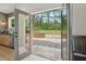 View of the patio and landscaped backyard through the open French doors from the kitchen at 4840 Moon Rd, Powder Springs, GA 30127