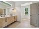 Bright bathroom with a double sink vanity, neutral walls, and tile floors, plus a view into the closet at 4840 Moon Rd, Powder Springs, GA 30127
