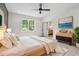 Bedroom with a ceiling fan, modern decor, a large window, and a doorway that leads to an ensuite bathroom at 4840 Moon Rd, Powder Springs, GA 30127