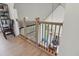 Upstairs hallway with wooden railing, hardwood floors, and a modern light fixture at 4840 Moon Rd, Powder Springs, GA 30127