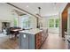 Modern kitchen open to the dining area with a large island featuring a white countertop and stainless steel appliances at 4840 Moon Rd, Powder Springs, GA 30127
