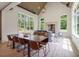 Open-concept living room and dining area with a wood-burning fireplace and bright natural light from large windows at 4840 Moon Rd, Powder Springs, GA 30127