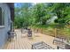 Large back deck with outdoor seating offers an ideal space for entertaining and enjoying the wooded view at 5148 Stratham Dr, Dunwoody, GA 30338