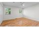 This bedroom has wood floors, windows, and a double closet with white trim at 5148 Stratham Dr, Dunwoody, GA 30338