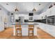 Modern kitchen featuring white cabinets, stainless steel appliances, and an island with bar seating at 5148 Stratham Dr, Dunwoody, GA 30338