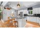 Modern kitchen featuring white cabinets, stainless steel appliances, a spacious island, and stylish pendant lighting at 5148 Stratham Dr, Dunwoody, GA 30338