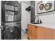 Modern laundry room featuring a stacked washer and dryer, marble countertop and stylish cabinet at 5148 Stratham Dr, Dunwoody, GA 30338
