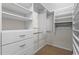 Organized walk-in closet with built-in shelving, drawers, and hanging rods at 5148 Stratham Dr, Dunwoody, GA 30338