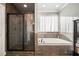 Well-lit bathroom with a glass-enclosed shower and a soaking tub with decorative tile accents at 121 Harmony Oaks Trl, Canton, GA 30115