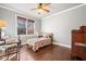 Simple bedroom featuring hardwood floors, a ceiling fan, and a large window with a nature view at 121 Harmony Oaks Trl, Canton, GA 30115