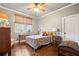 Cozy bedroom featuring hardwood floors, a ceiling fan, and a window with a view of the outdoors at 121 Harmony Oaks Trl, Canton, GA 30115