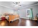 Bedroom features hardwood floors, two windows with curtains, and a wooden bed frame at 121 Harmony Oaks Trl, Canton, GA 30115
