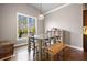 Bright dining room with large window, hardwood floors, rustic table, and modern light fixture at 121 Harmony Oaks Trl, Canton, GA 30115
